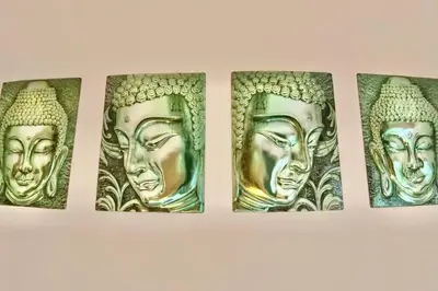 four gold buddha statues hanging on a wall at Zezita's Place in São Jorge