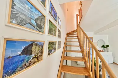 a staircase in a home with pictures on the wall at Zezita's Place in São Jorge