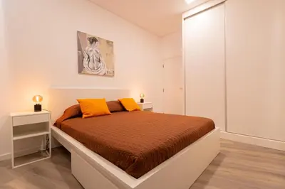 a bedroom with a large bed with orange pillows at VIP Baía Beach in Machico