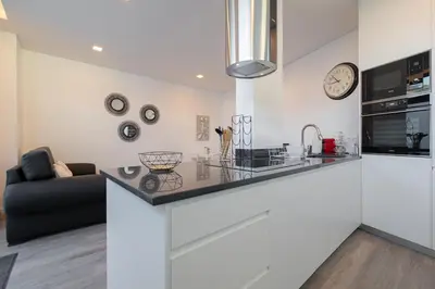 a white kitchen with a counter and a couch at VIP Baía Beach in Machico