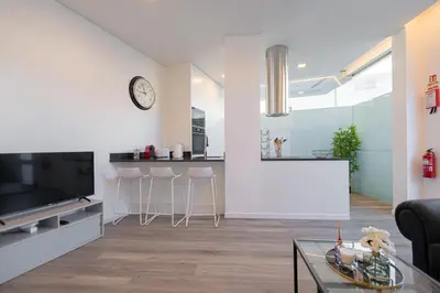 a living room with a tv and a table at VIP Baía Beach in Machico
