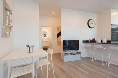a kitchen and living room with a white table and chairs at VIP Baía Beach in Machico