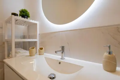 a bathroom with a sink and a mirror at VIP Baía Beach in Machico