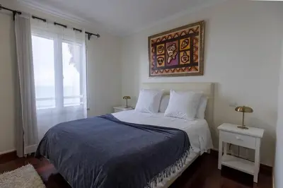 a bedroom with a bed with a blue comforter at Formosa Beach Apartment Vista Mar a 2 Minutos da Praia in Funchal