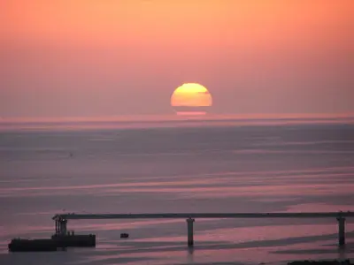 a sunset over the ocean with the sun in the horizon at Formosa Beach Apartment Vista Mar a 2 Minutos da Praia in Funchal