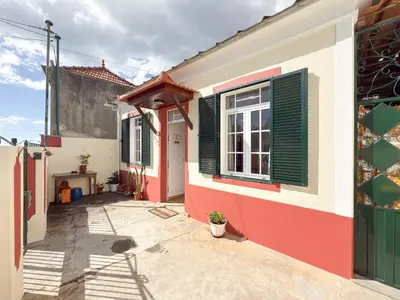 a house with a red and white facade with a window at Funchal Bartolomeu Explorers in Funchal