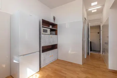 a kitchen with white cabinets and a refrigerator at Funchal Bartolomeu Explorers in Funchal