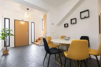 a dining room with a table and yellow chairs at Vila Margot by Rent-a-key in Caniço