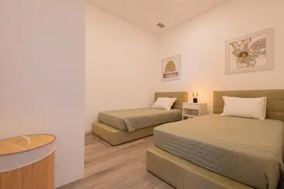 a bedroom with two beds and a table and a sink at VIP Baía Beach B in Machico