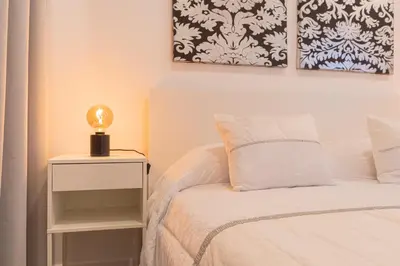 a bedroom with a bed and a lamp on a night stand at VIP Baía Beach B in Machico