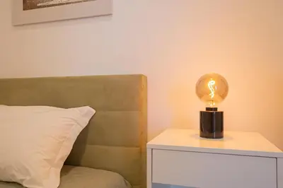 a light bulb on a night stand next to a bed at VIP Baía Beach B in Machico