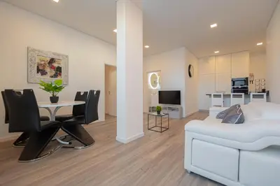 a bedroom with a bed and a table and chairs at VIP Baía Beach B in Machico