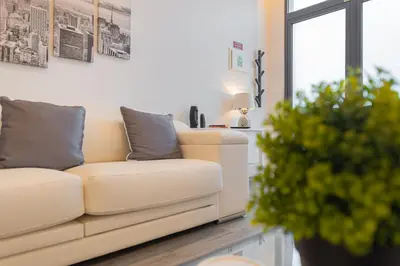 a white couch in a living room with a plant at VIP Baía Beach B in Machico