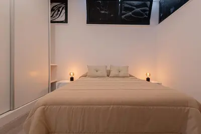 a bedroom with a large bed with two lamps on it at VIP Baía Beach C in Machico