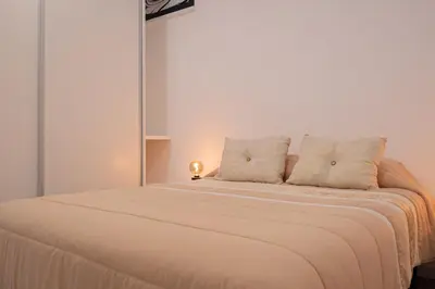 a white bed with two pillows on top of it at VIP Baía Beach C in Machico