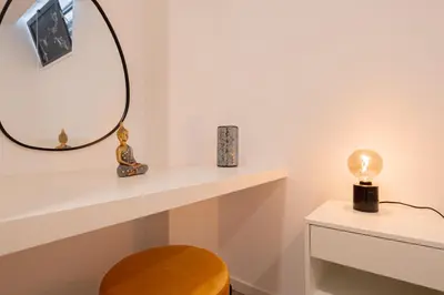 a dressing room with a mirror and a stool at VIP Baía Beach C in Machico