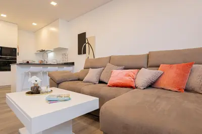 a living room with a couch and a table at VIP Baía Beach C in Machico