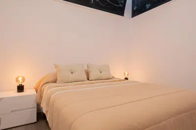 a bedroom with a bed with two lamps on it at VIP Baía Beach C in Machico