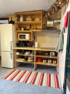 a kitchen with wooden shelves and a refrigerator at Casa Vintage Seixal Madeira in Seixal