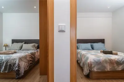 a mirror reflection of a bedroom with two beds at Casa Estrela Dos Reis in Estreito da Calheta