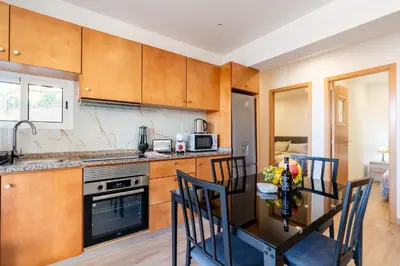 a kitchen with a table and chairs in a kitchen at Casa Estrela Dos Reis in Estreito da Calheta
