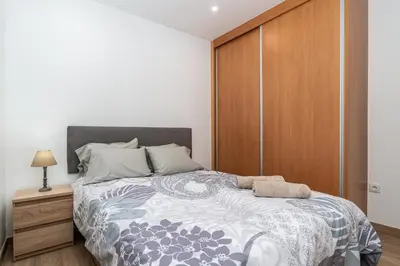 a bedroom with a large bed with a wooden cabinet at Casa Estrela Dos Reis in Estreito da Calheta