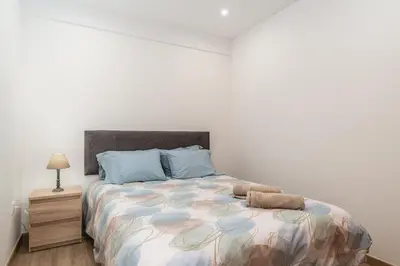 a bedroom with a large bed with blue pillows at Casa Estrela Dos Reis in Estreito da Calheta