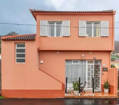 a orange house with white shutters at Campo & Mar Apartments in Porto Moniz