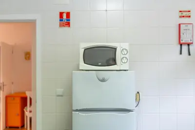 a microwave sitting on top of a refrigerator at Campo & Mar Apartments in Porto Moniz