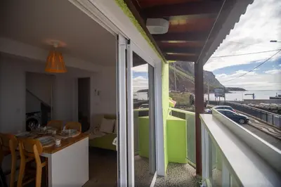 a room with a balcony with a view of the ocean at Wave Shadows Beach House Oceanfront property - Top Floor in Paul do Mar