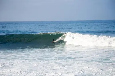 a person riding a wave on a surfboard in the ocean at Wave Shadows Beach House Oceanfront property - Top Floor in Paul do Mar