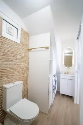 a white bathroom with a toilet and a sink at Wave Shadows Beach House Oceanfront property - Top Floor in Paul do Mar