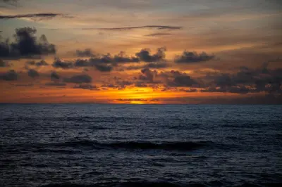 a sunset over the ocean with the sun setting at Wave Shadows Beach House Oceanfront property - Top Floor in Paul do Mar