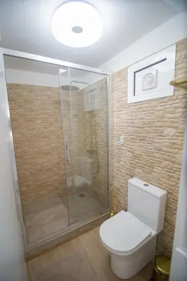 a bathroom with a toilet and a glass shower at Wave Shadows Beach House Oceanfront property - Top Floor in Paul do Mar