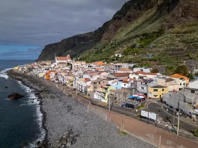 a group of houses on a hill next to the ocean at Wave Shadows Beach House Oceanfront property - Bottom Floor in Paul do Mar