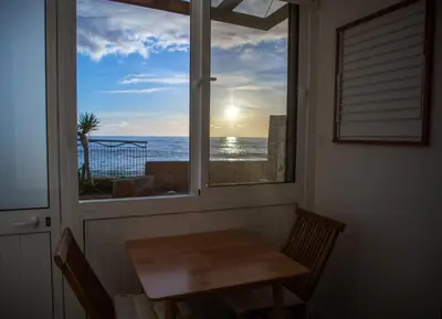 a window with a table and a view of the ocean at Wave Shadows Beach House Oceanfront property - Bottom Floor in Paul do Mar