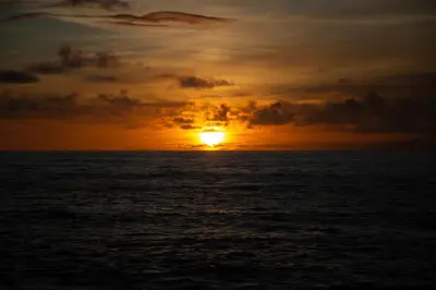 a sunset over the ocean with the sun setting at Wave Shadows Beach House Oceanfront property - Bottom Floor in Paul do Mar