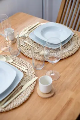 a table with plates and glasses on a wooden table at Wave Shadows Beach House Oceanfront property - Bottom Floor in Paul do Mar