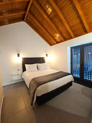 a bedroom with a large bed and a wooden ceiling at Quinta das Rosas 6 Amaizing Seaview Trekking Beach in Estreito da Calheta