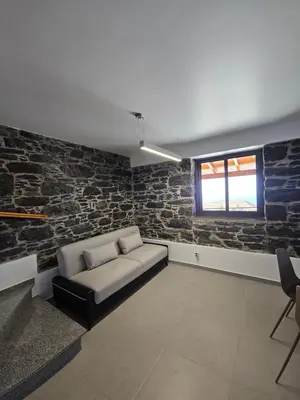 a living room with a couch and a brick wall at Quinta das Rosas 6 Amaizing Seaview Trekking Beach in Estreito da Calheta