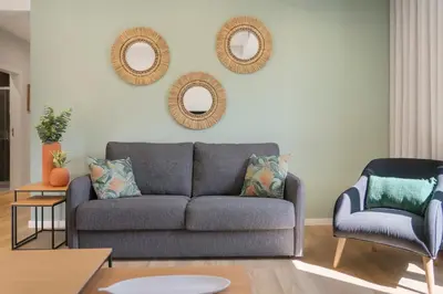a living room with a couch and a chair and mirrors at Atlantic Blue 2 - central and with garage in Funchal