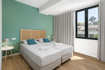 a bedroom with a large white bed and a window at Atlantic Blue 2 - central and with garage in Funchal