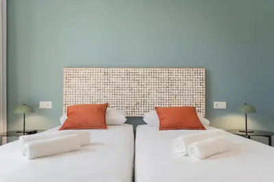 two beds with red and white pillows in a room at Atlantic Blue 2 - central and with garage in Funchal