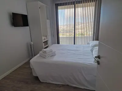 a bedroom with a bed with white sheets and a window at Ocean Paradise de Santa Luzia in Funchal