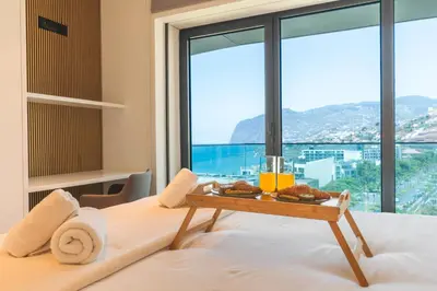 a hotel room with a tray of food on a bed at Majestic Penthouse View by Atlantic Holiday in Funchal