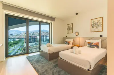 two beds in a room with a large window at Majestic Penthouse View by Atlantic Holiday in Funchal