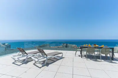 a patio with a table and chairs and the ocean at Majestic Penthouse View by Atlantic Holiday in Funchal