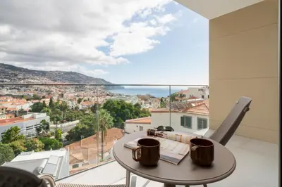 a balcony with a table and a view of the city at Maravilhas II by An Island Apart in Funchal
