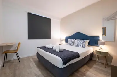 a bedroom with a large bed with a blue headboard at Lux City Center Apartment 2 in Funchal