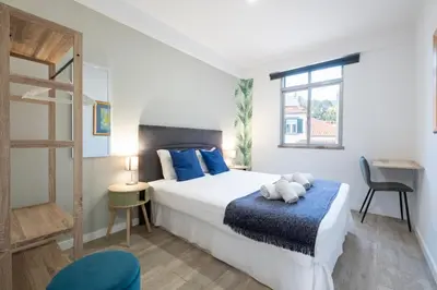 a bedroom with a large white bed with blue pillows at Lux City Center Apartment 2 in Funchal